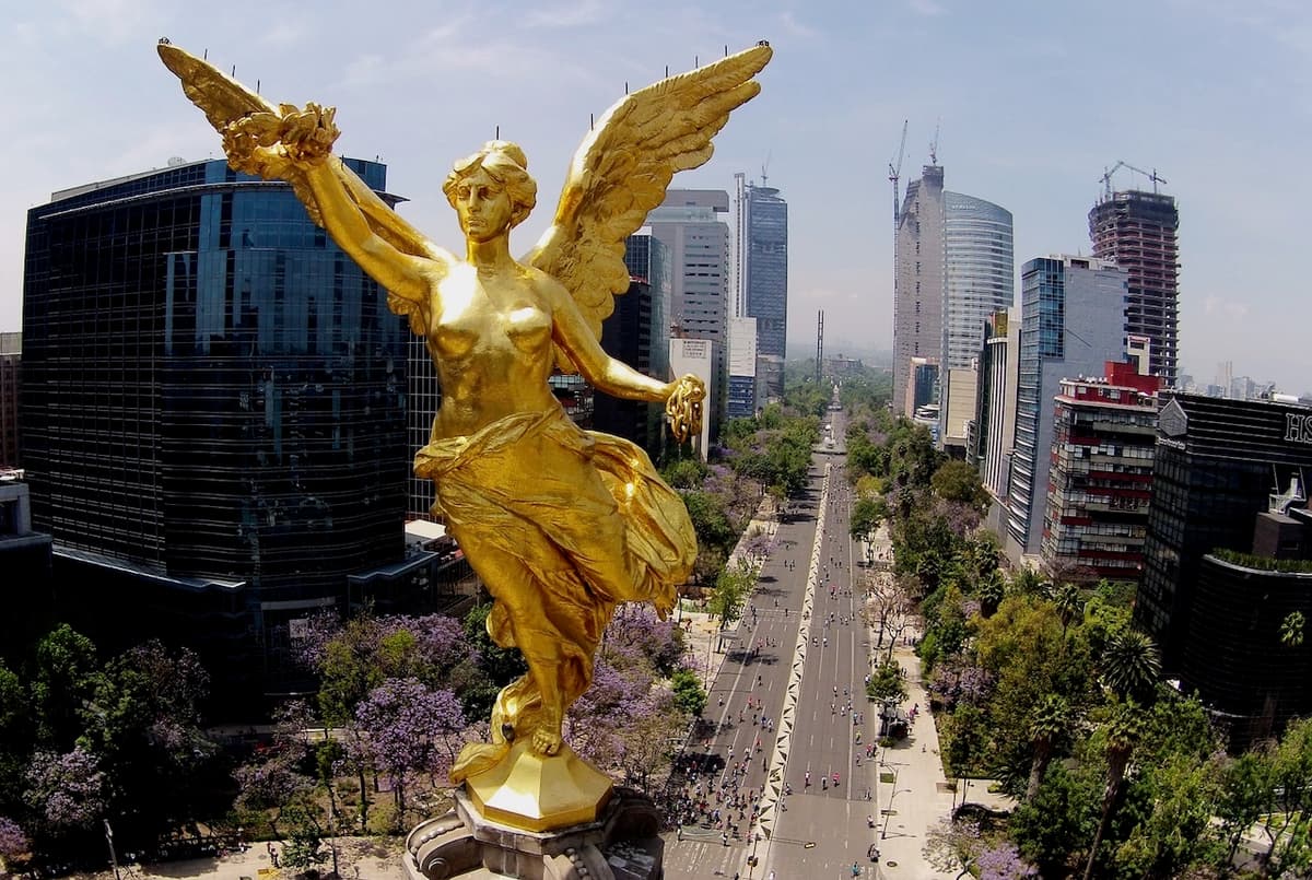 Vista del Ángel de la Independencia con edificios de Monterrey al fondo, simbolizando la modernización y ventilación eficiente con CW80 SUPERCOOL de Climate Gate.
