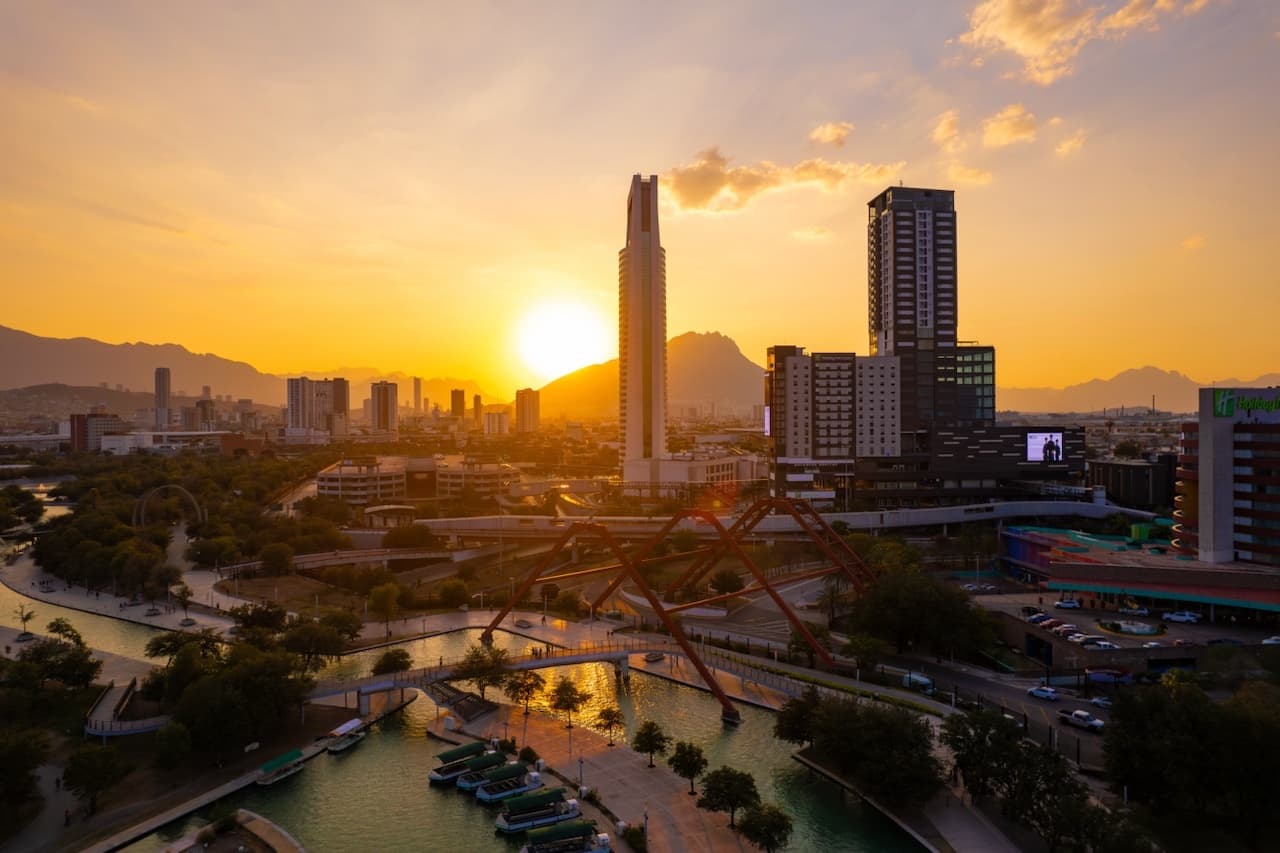 Atardecer en Monterrey con un edificio moderno en primer plano, simbolizando la integración de soluciones de ventilación avanzadas como el CW80 SUPERCOOL.