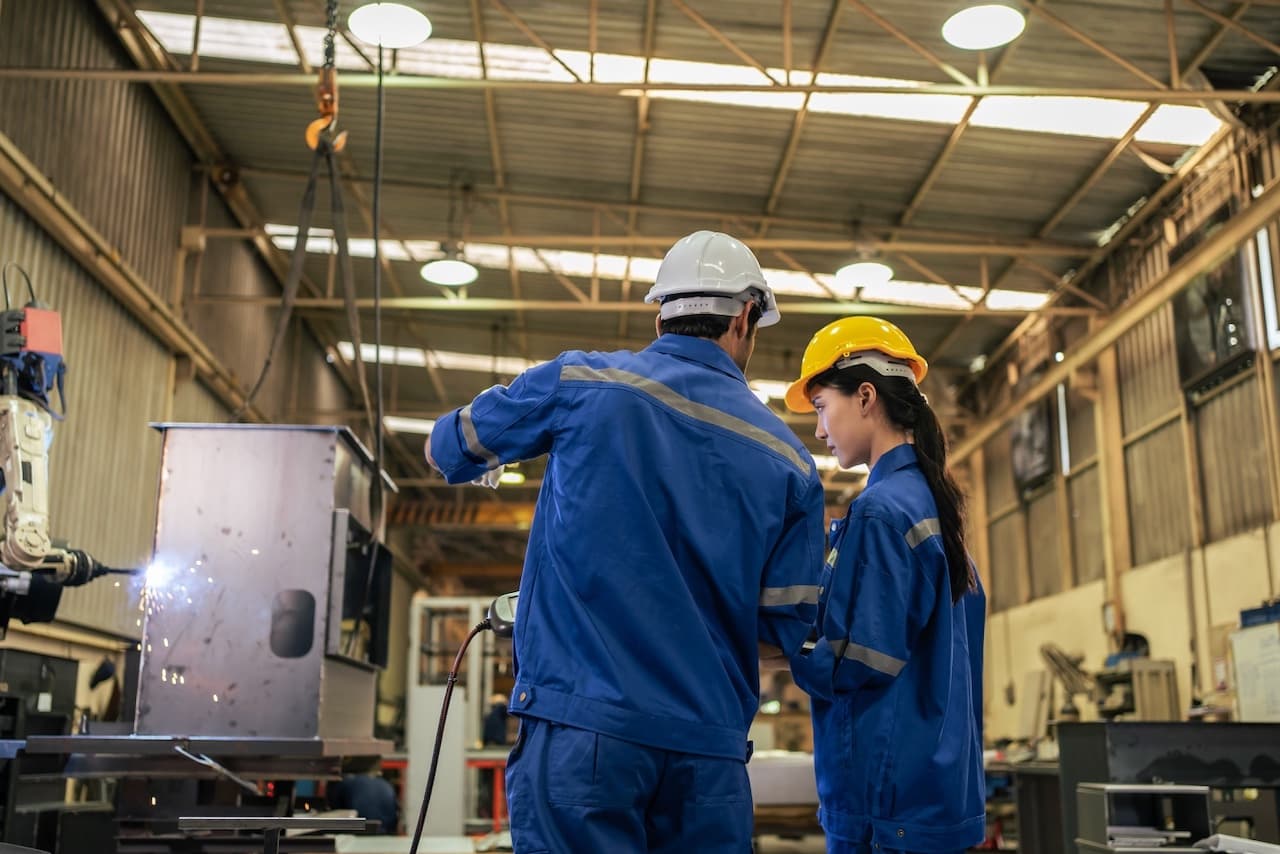 Ingenieros revisando los sistemas CW80 SUPERCOOL en una planta industrial, garantizando su eficiencia en la ventilación de espacios complejos.