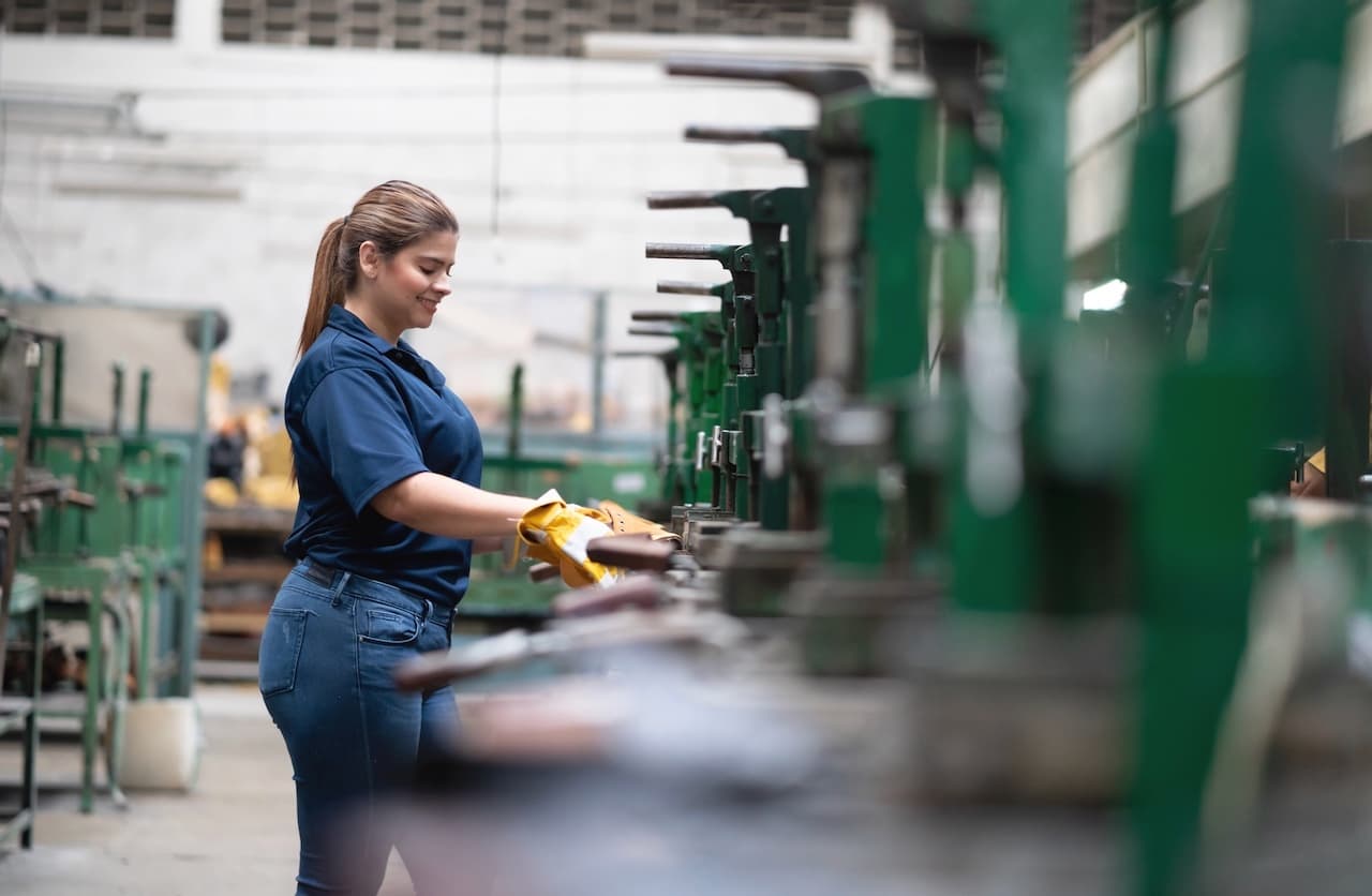Trabajadora en una línea de producción industrial, simbolizando la aplicación de los sistemas HVAC CW-3 en manufactura.