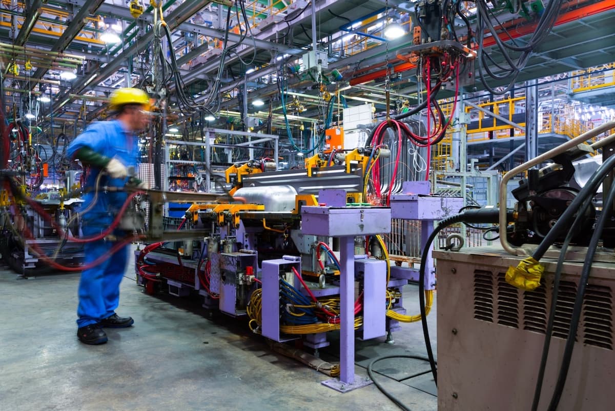 Interior de una planta de producción con tuberías y equipos CW80 IEC, mostrando cómo el sistema de ventilación se integra en la industria.