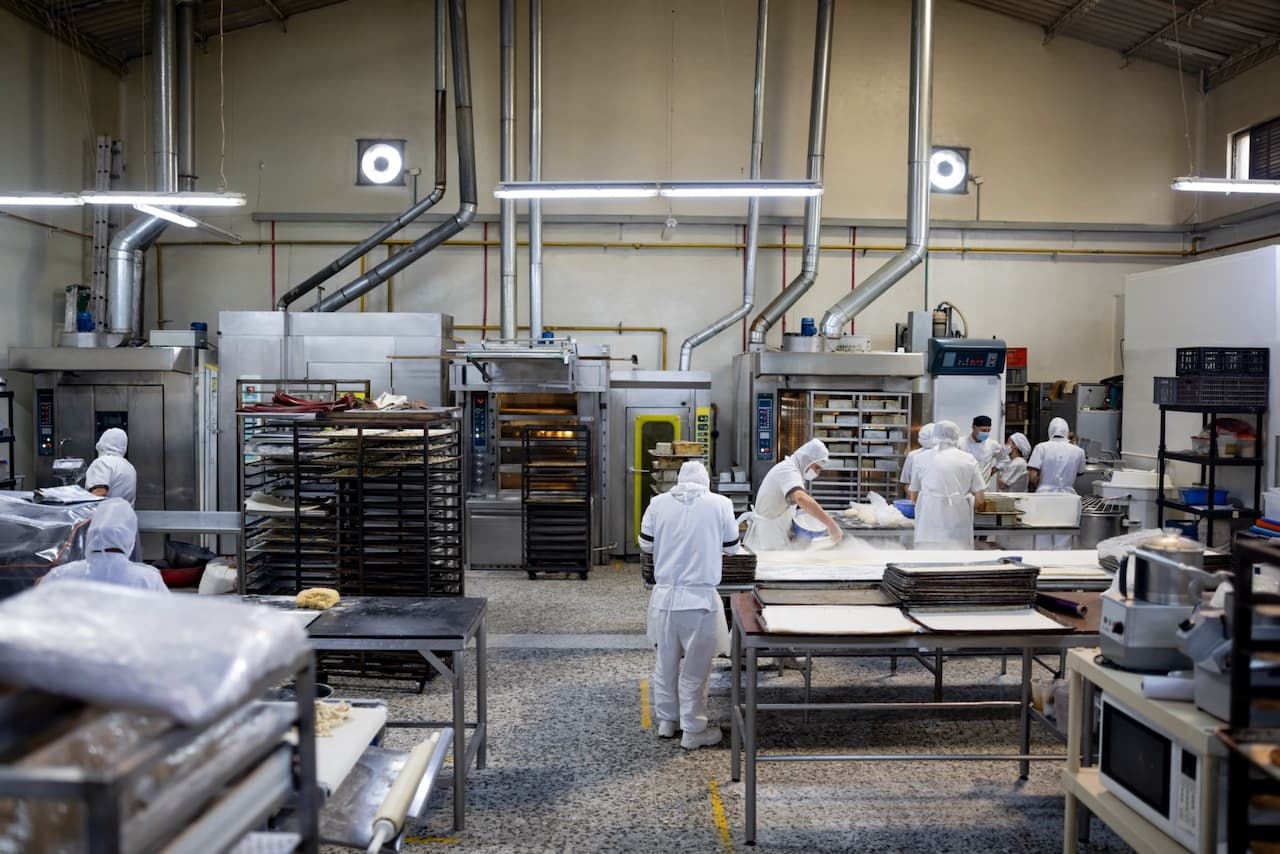 Interior de una instalación industrial con equipos CW80 IEC manteniendo la ventilación adecuada para procesos de producción alimentaria.