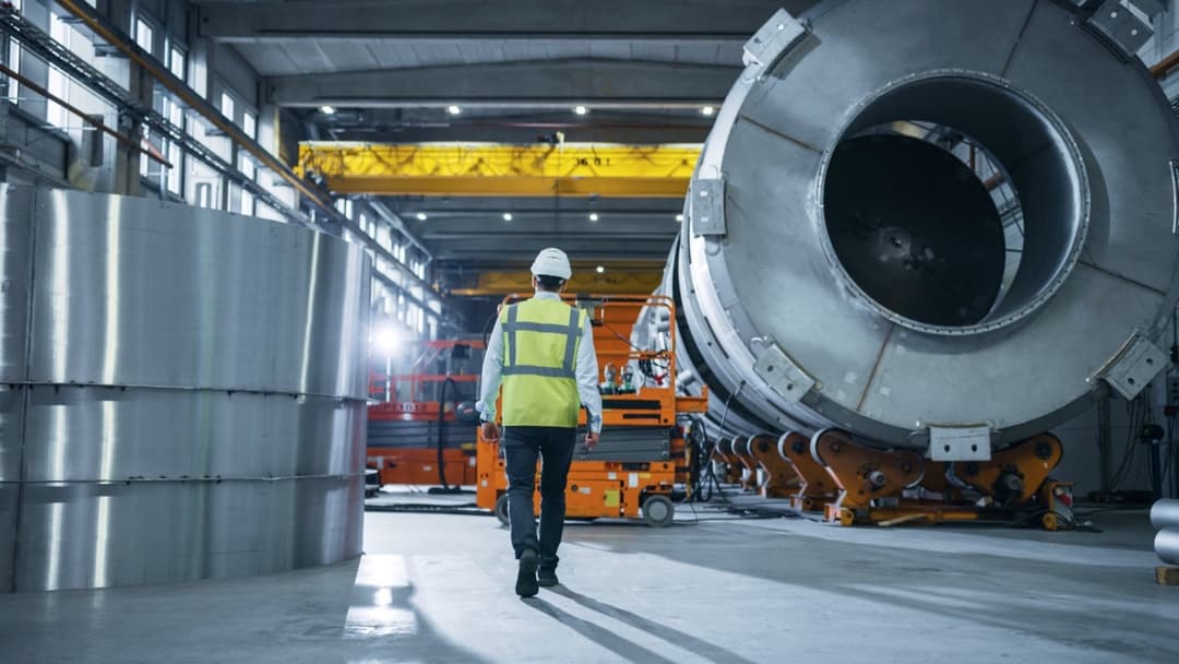 Trabajador en una planta industrial operando maquinaria, representando el compromiso de Climate Gate en distribuir Equipos de Aire Acondicionado Industriales para mejorar la eficiencia laboral.