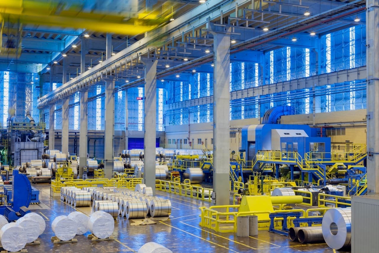 Amplio espacio industrial con líneas de producción y sistemas de ventilación Mobile Max 3, optimizando el flujo de aire y la comodidad de los trabajadores.