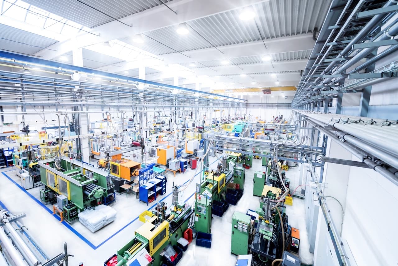 Gran fábrica con múltiples estaciones de trabajo y Equipos de Aire Acondicionado Portátiles proporcionando ventilación eficiente en todas las áreas.