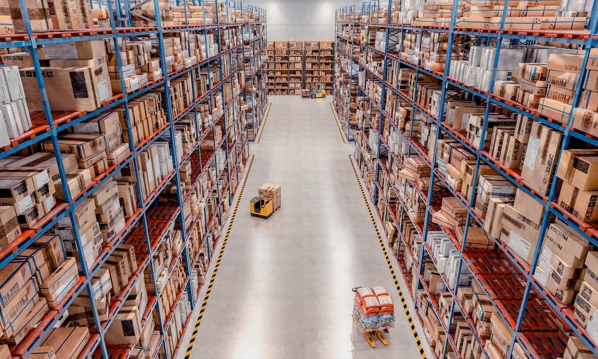 Almacén industrial con pasillos amplios y estanterías altas, donde Equipos de Aire Acondicionado Portátiles aseguran una buena circulación del aire.