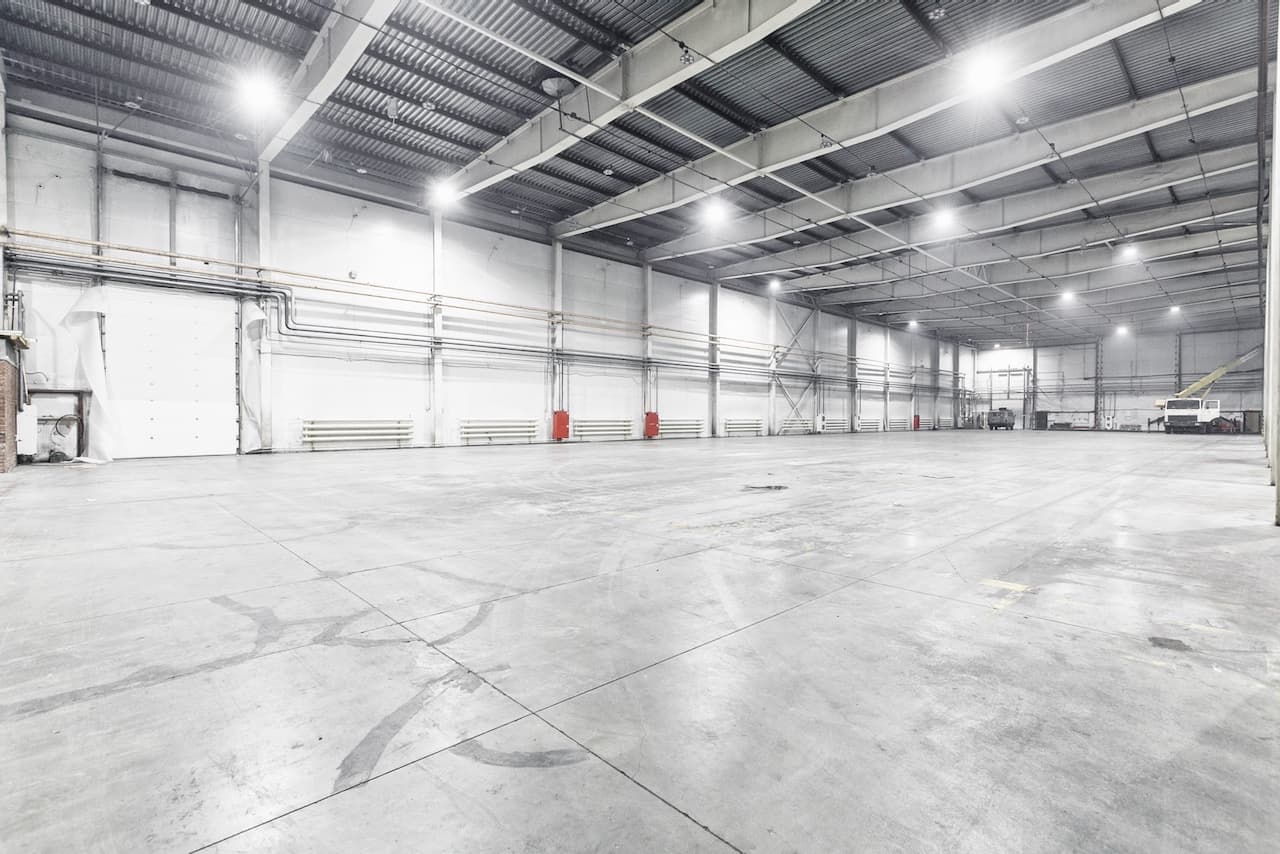 Espacio industrial vacío con techos altos y ventilación CW80 SUPERCOOL, mostrando su capacidad para enfriar grandes superficies.