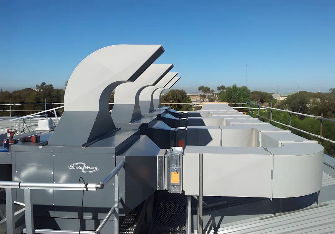 Vista panorámica de Monterrey desde un techo industrial, mostrando ventiladores CW-H10 instalados para mejorar la calidad del aire.