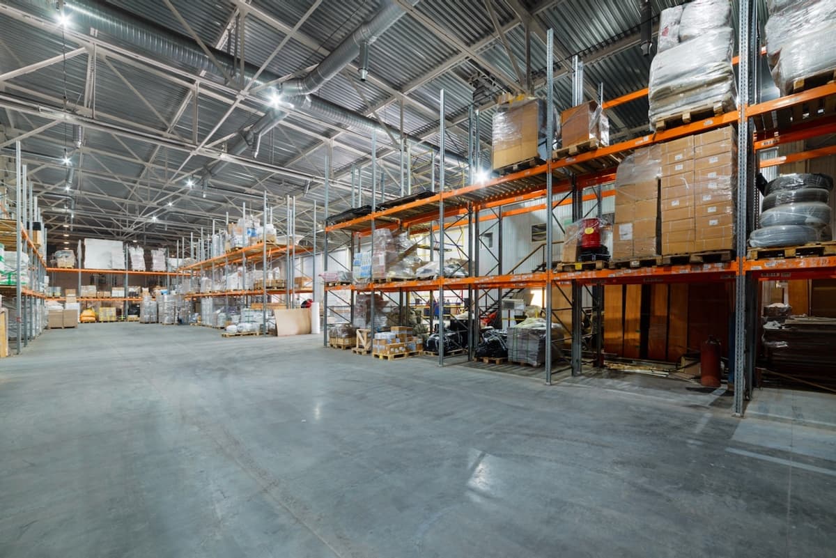 Interior de un almacén industrial con estanterías llenas, representando la logística de distribución CW-3 en Colombia.