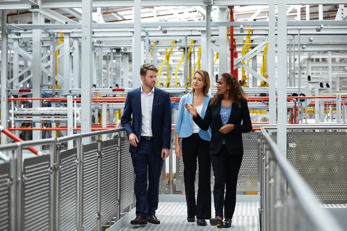Reunión de ejecutivos en un almacén industrial, representando la planificación y estrategia detrás de los equipos CW-3.