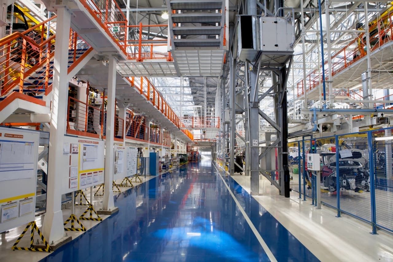 Corredor de una planta industrial con tuberías y sistemas de climatización, mostrando la integración de Equipos de Aire Acondicionado Industriales de Climate Gate.