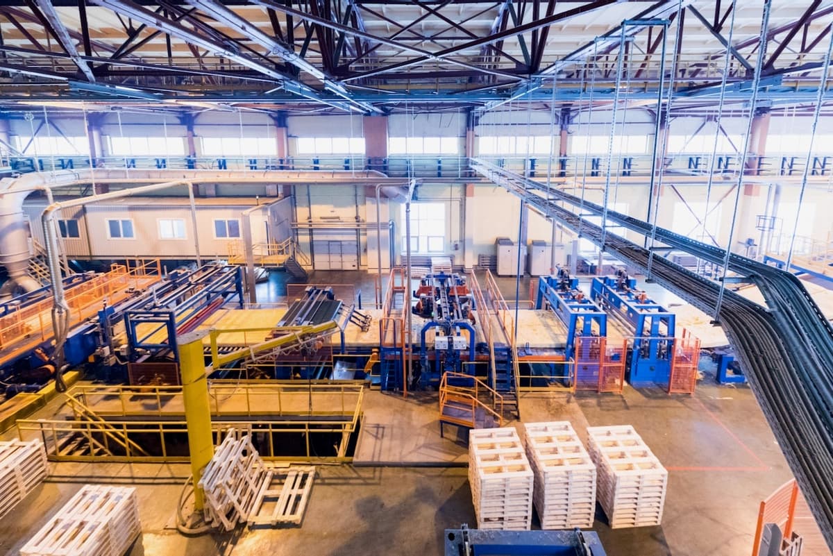 Línea de producción con trabajadores y equipo de manufactura, ventilados con Mobile Max 2 de Climate Gate para un entorno de trabajo más saludable.