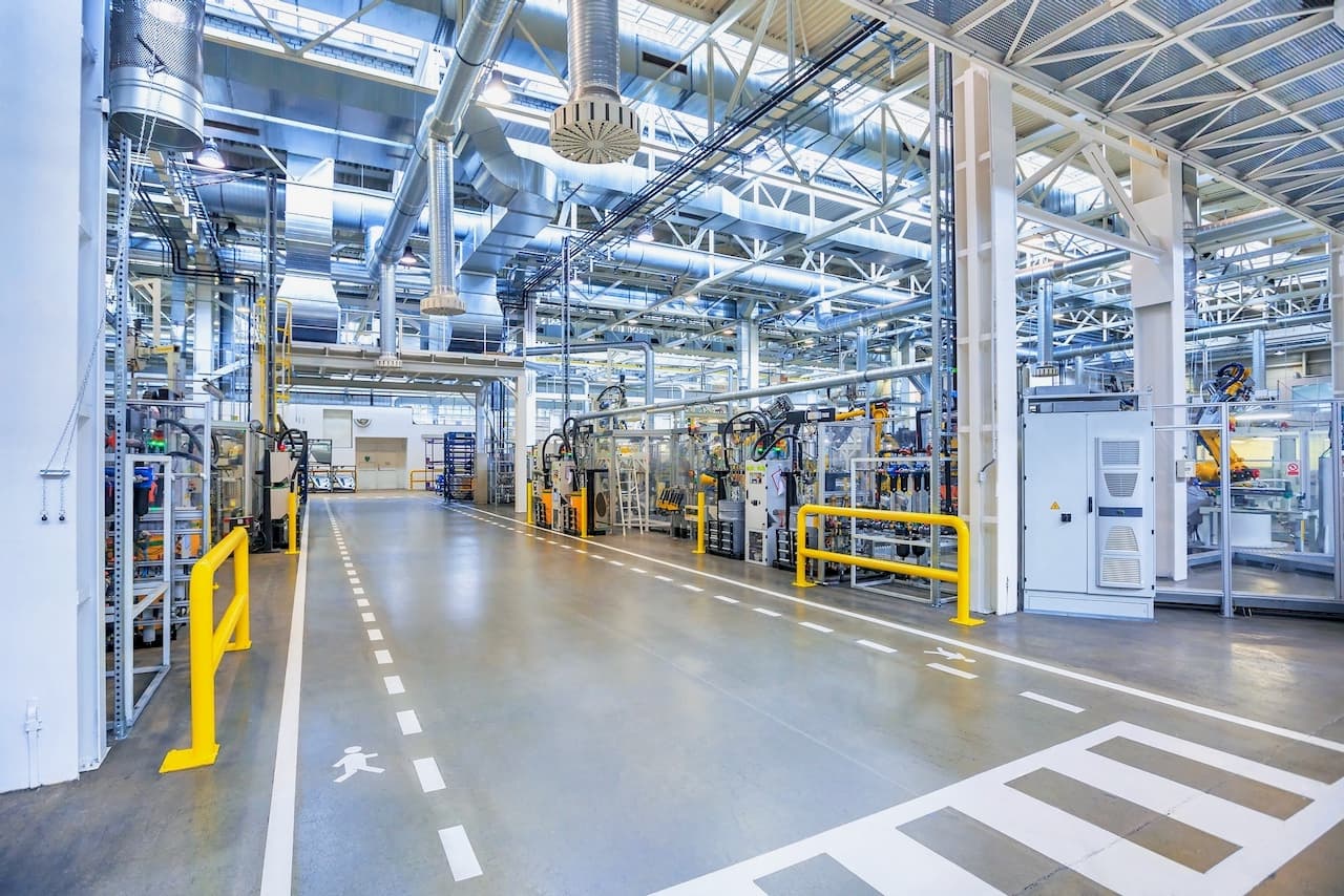 Interior de una fábrica con el sistema TBS-580 instalado, asegurando una ventilación constante y eficiente en toda la línea de producción.