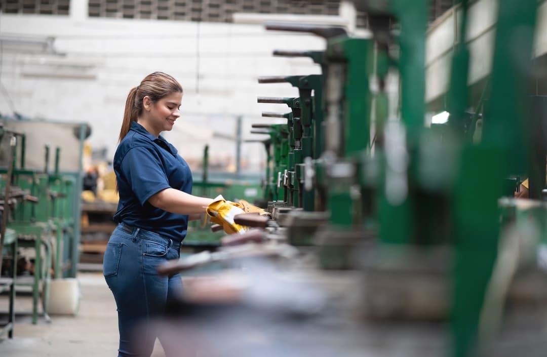 Trabajadora en una línea de ensamblaje con ventilación adecuada gracias al equipo TBS-580, mejorando la eficiencia y confort en el proceso industrial.