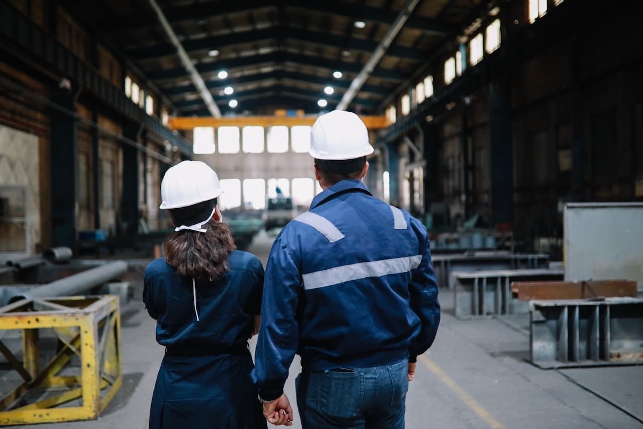 Trabajadores industriales con equipo de protección, mostrando el entorno seguro proporcionado por los sistemas de ventilación TBS-580 de Climate Gate.